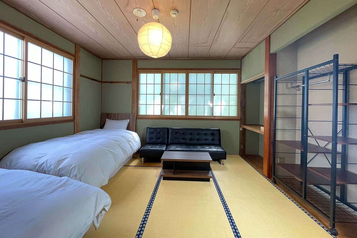 Two large comfy beds in a traditional Japanese room.
