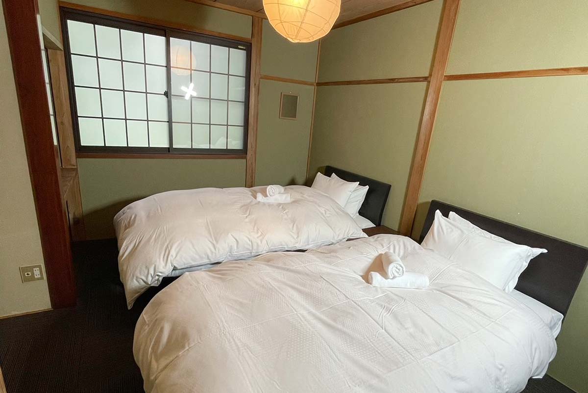 Two large comfy beds in a traditional Japanese room.